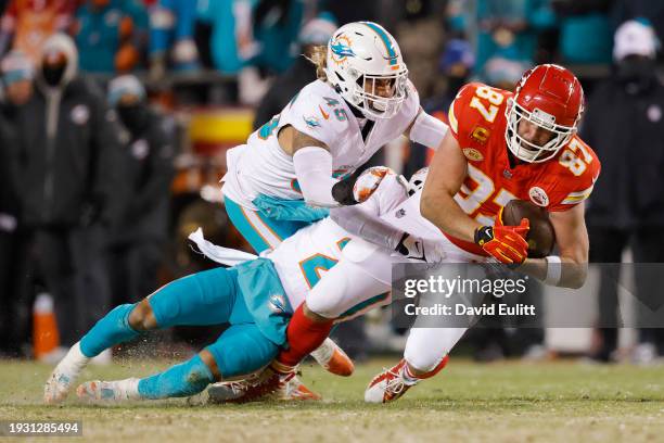 Travis Kelce of the Kansas City Chiefs is tacked by Brandon Jones and Duke Riley of the Miami Dolphins during the second quarter in the AFC Wild Card...