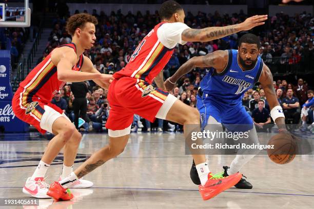 Dyson Daniels and Jordan Hawkins of the New Orleans Pelicans guard Kyrie Irving of the Dallas Mavericks in the first half at American Airlines Center...