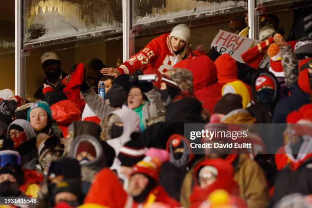 Taylor Swift celebrates with fans during the AFC Wild Card Playoffs between the Miami Dolphins and the Kansas City Chiefs at GEHA Field at Arrowhead...