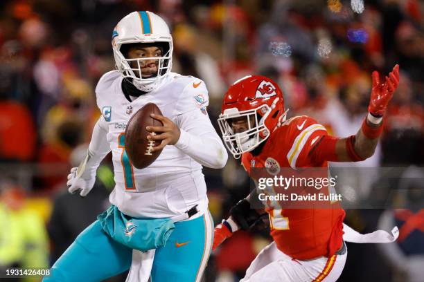 Tua Tagovailoa of the Miami Dolphins runs as he is pursued by Mike Edwards of the Kansas City Chiefs during the second half in the AFC Wild Card...