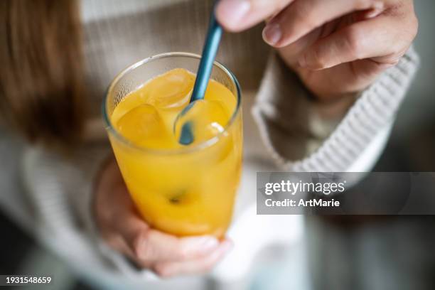 woman putting metal straw in her drink - frisdrank stockfoto's en -beelden