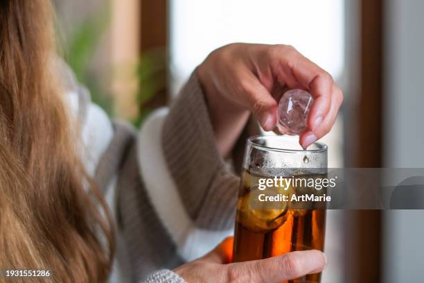 woman removing ice from her ice tea or soda drink because of dental problems - ice tea stock pictures, royalty-free photos & images