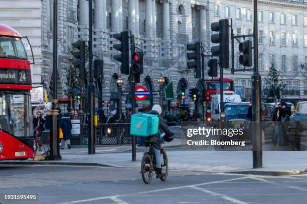 Food delivery courier working for Deliveroo Plc cycles through Piccadilly Circus in central London, UK, on Tuesday, Jan. 16, 2024. Food delivery...