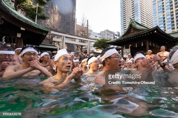 Participants bathe in ice-cold water during a Shinto ritual at Teppozu Inari Shrine on January 14, 2024 in Tokyo, Japan. The annual new year event...