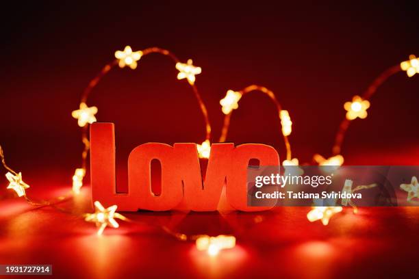 love word decoration on dark red with string lights - anniversary card stock pictures, royalty-free photos & images