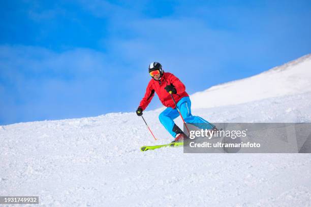 active lifestyle, vital senior  men snow skier skiing, enjoying on sunny ski resorts sellaronda, dolomiti superski. skiing carving at high speed against blue sky. - alpine skiing stockfoto's en -beelden