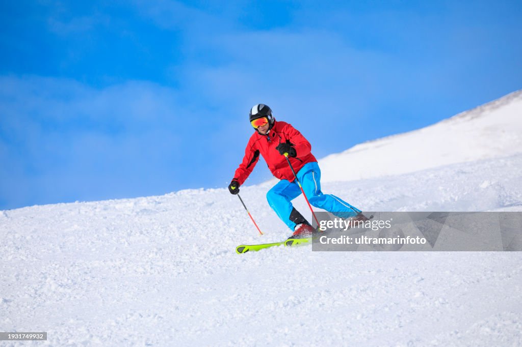 Active lifestyle, Vital senior men snow skier skiing, enjoying on sunny ski resorts Sellaronda, Dolomiti superski. Skiing carving at high speed against blue sky.