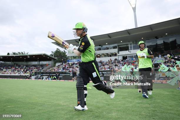 David Warner of the Thunder runs out to open the batting during the BBL match between Sydney Thunder and Adelaide Strikers at Manuka Oval, on January...