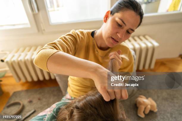mother doing head lice cleaning on daughter at home - lice close up stock pictures, royalty-free photos & images