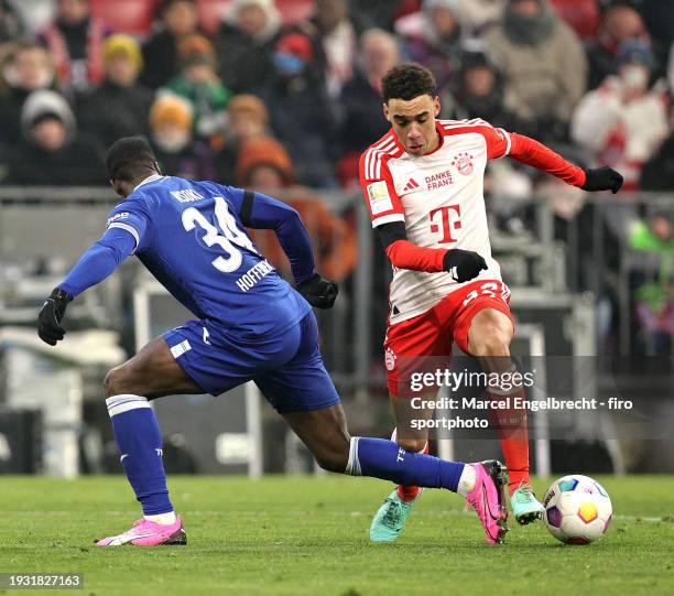Stanley Nsoki of TSG Hoffenheim and Jamal Musiala of FC Bayern München compete for the ball during the Bundesliga match between FC Bayern München and...