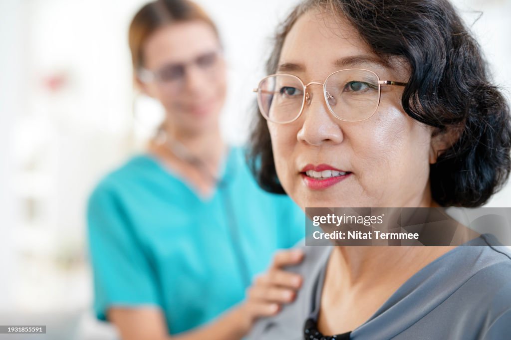 Homecare Service for Seniors to Maintaining Health Quality. A senior patient gets a health consultation from a female doctor while examining via a stethoscope during a home visit.