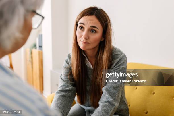 upset young woman talking with female psychologist in therapy session. - kindness stock pictures, royalty-free photos & images