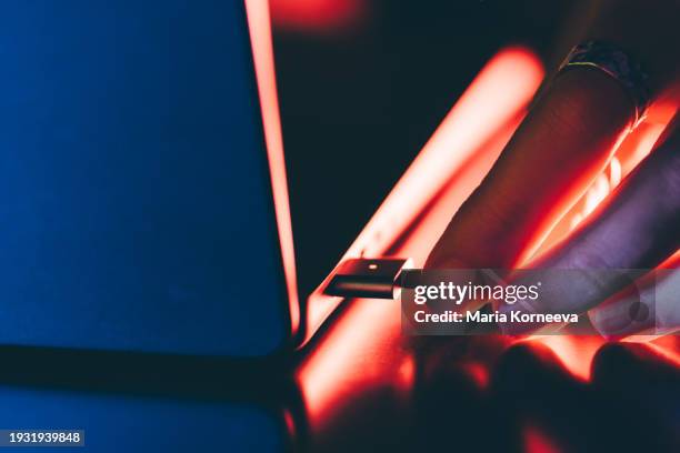 laptop connected with power supply cable charger. woman connecting laptop charger. - plugging in stock pictures, royalty-free photos & images