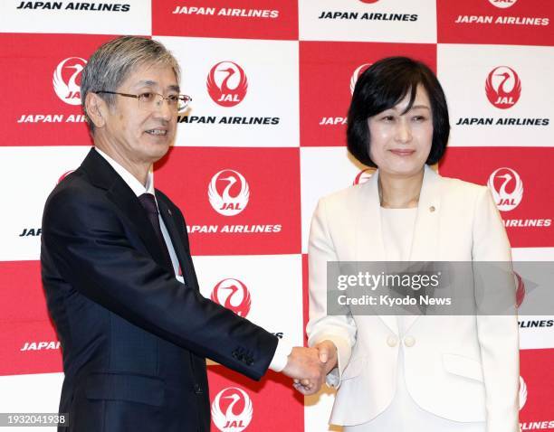 Japan Airlines Co. President Yuji Akasaka and senior managing executive officer Mitsuko Tottori, a former flight attendant, shake hands at a press...