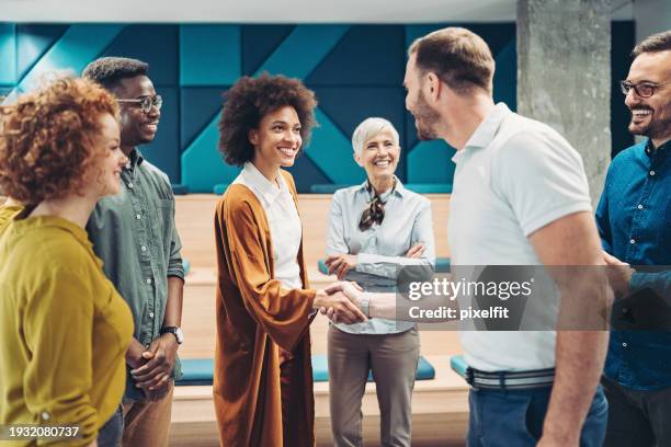 businesswoman congratulating a colleague - welcome 2021 stock pictures, royalty-free photos & images