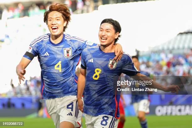 Takumi Minamino of Japan celebrates with teammate Ko Itakura after scoring his team's first goal during the AFC Asian Cup Group D match between Japan...