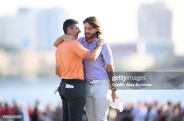 Rory McIlroy of Northern Ireland and Tommy Fleetwood of England embrace on the 18th green as Fleetwood wins the Dubai Invitational at Dubai Creek...