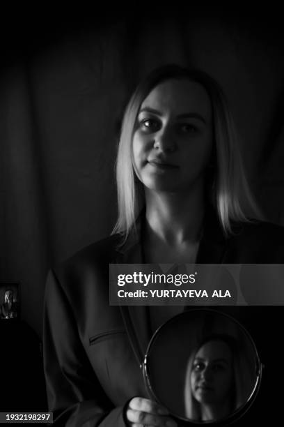 portrait of a beautiful girl with blond hair with reflection in the mirror. black and white photo. - black and white instant print stock pictures, royalty-free photos & images