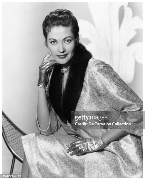 Publicity portrait of Yvonne De Carlo donning a fashionable metallic outfit with matching gloves in the late 1950’s, United States.