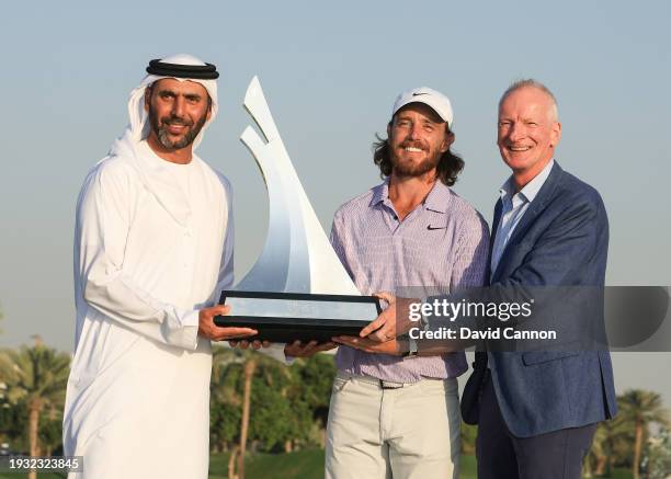 Tommy Fleetwood of England poses with the Dubai Invitational Trophy with Abdulla Al Naboodah the host of the event and David Brookes from The DP...