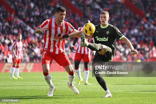 Artem Dovbyk of Girona FC controls the ball under pressure from Cesar Montes of UD Almeria during the LaLiga EA Sports match between UD Almeria and...
