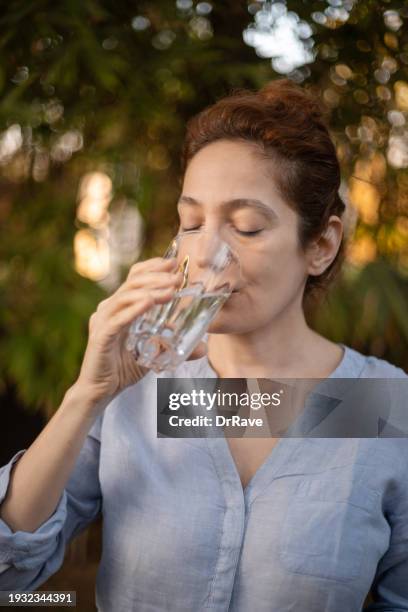 caucasian woman taking a sip of cold water after removing the ice, relieved , part of a series for sensitive teeth - drink stock pictures, royalty-free photos & images