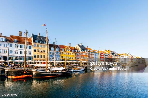multi-colored vibrant houses in nyhavn harbour on a sunny summer day with clear blue sky, copenhagen, denmark - köpenhamn bildbanksfoton och bilder
