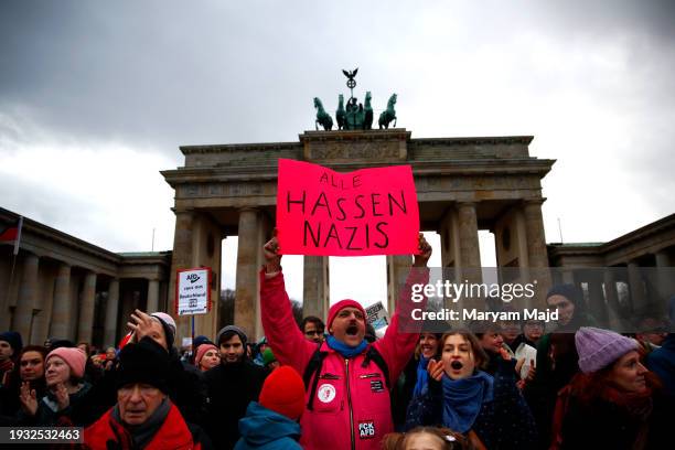 Demonstrator holds a placard in German saying "Everyone hates Nazis" during a pro-democracy demonstration in front of the Brandenburg Gate following...