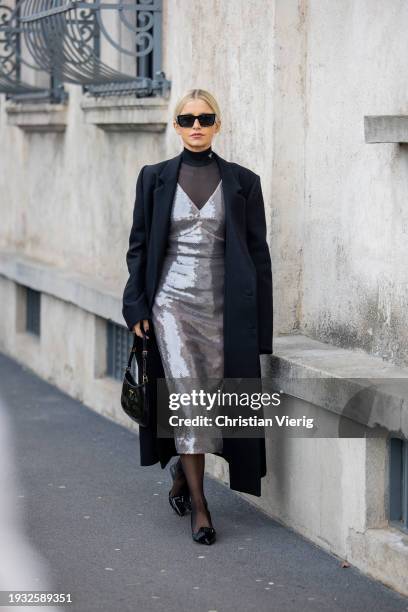 Caroline Caro Daur wears silver sequined dress, black coat, tights, bag, heels, turtleneck, sunglasses outside Prada during the Milan Fashion Week -...