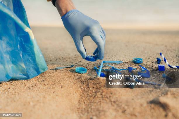 plastic bottles and other trash on sea beach - multi coloured glove stock pictures, royalty-free photos & images