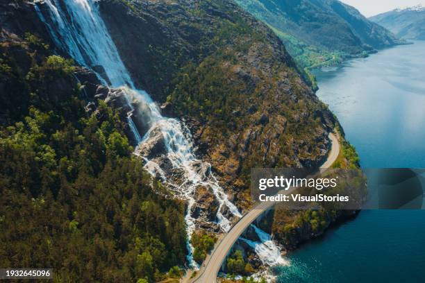 aerial view of idyllic mountain road above scenic waterfall in norway - georganiseerde groepen stockfoto's en -beelden
