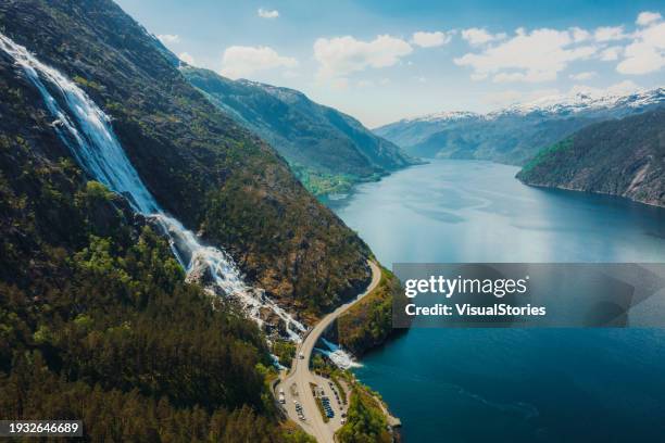 aerial view of car driving idyllic mountain road above scenic waterfall in norway - green bridge over trees stock pictures, royalty-free photos & images