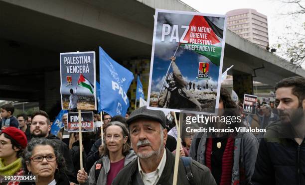 Demonstrators hold signs and flags while marching from the U.S Embassy to Israeli Embassy during a protest "for peace in the Middle East, for an end...