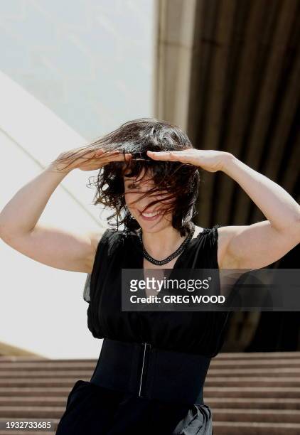Academy award winning French actress Juliette Binoche struggles to keep her hair in place during windy conditions on the steps of the Sydney Opera...