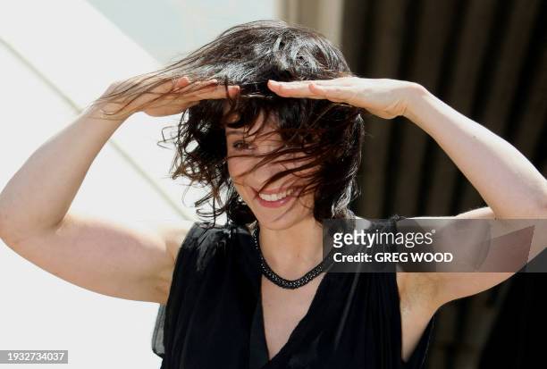 Academy award winning French actress Juliette Binoche struggles to keep her hair in place during windy conditions on the steps of the Sydney Opera...