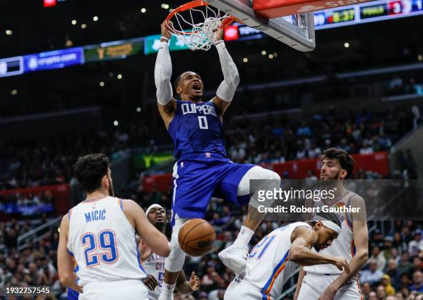 Los Angeles, CA, Tuesday, January 16, 2024 - LA Clippers guard Russell Westbrook slam dunks over three Oklahoma City Thunder players during second...