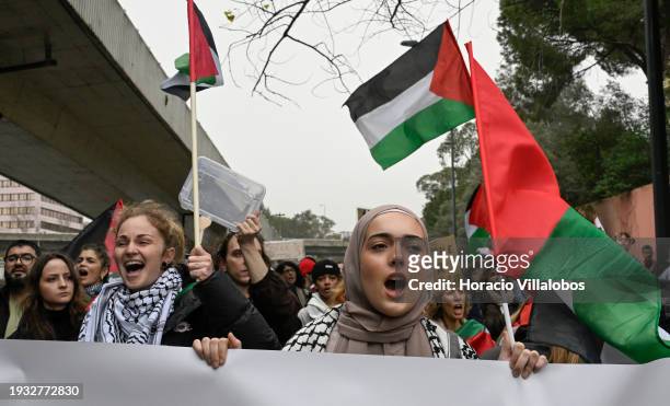 Demonstrators chant and hold Palestinian flags while marching from the U.S Embassy to Israeli Embassy during a protest "for peace in the Middle East,...