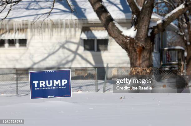 Campaign sign supporting former President Donald Trump is stuck in the snow on January 14 in Des Moines, Iowa. The states voters prepare for the...