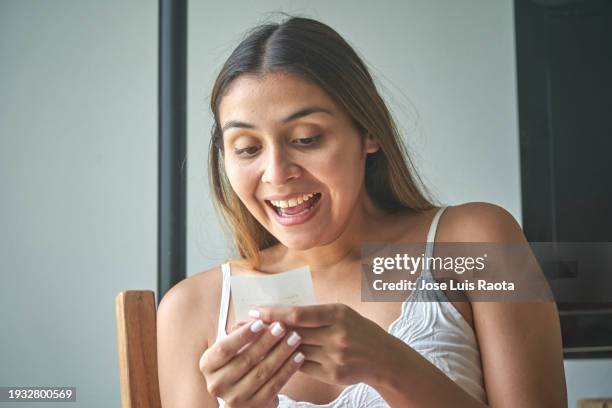 excited women looking at lottery ticket - sorte imagens e fotografias de stock