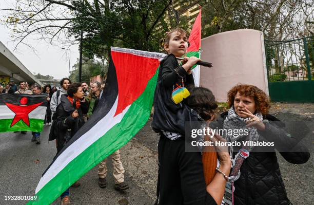 Child sits on her mother's shoulders holding a Palestinian flag while marching from the U.S Embassy to Israeli Embassy during a protest "for peace in...