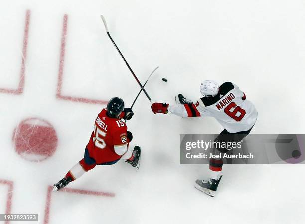 Anton Lundell of the Florida Panthers shoots the puck while being defended by John Marino of the New Jersey Devils at the Amerant Bank Arena on...