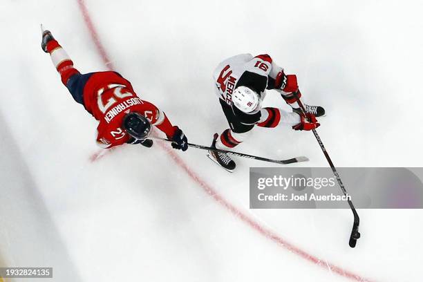 Eetu Luostarinen of the Florida Panthers attempts to take the puck from Dawson Mercer of the New Jersey Devils at the Amerant Bank Arena on January...