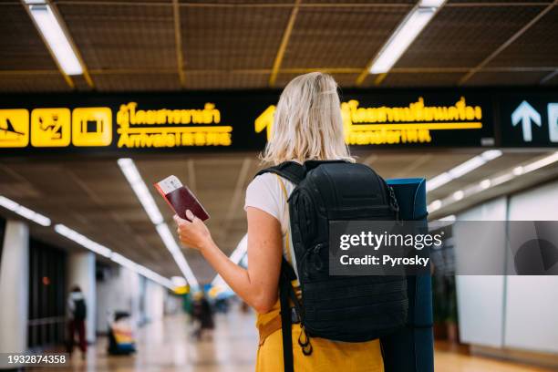 a woman at the airport holding a passport with a boarding pass - exercise mat stock pictures, royalty-free photos & images