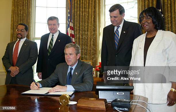 President George W. Bush, flanked by Assistant Attorney General for Civil Rights Ralph Boyd, Attorney General John Ashcroft, Secretary of Housing and...