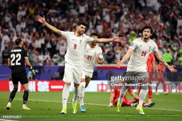 Sardar Azmoun of Iran celebrates with teammates Mehdi Taremi and Mohammad Mohebi of Iran after scoring their team's fourth goal during the AFC Asian...