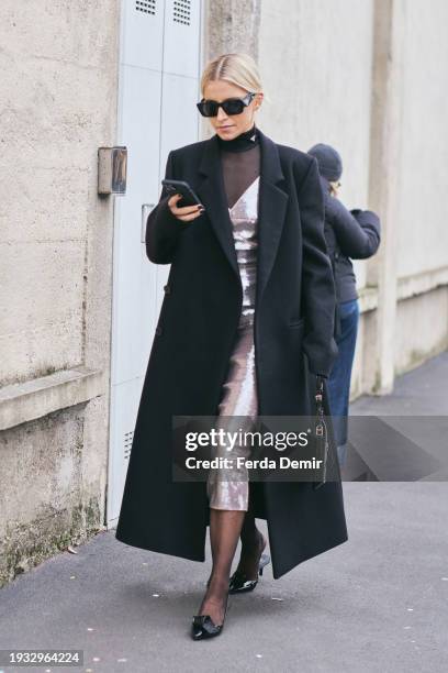 Caroline Caro Daur wears silver sequined dress, black coat, tights, bag, heels, turtleneck, sunglasses outside Prada during the Milan Fashion Week -...