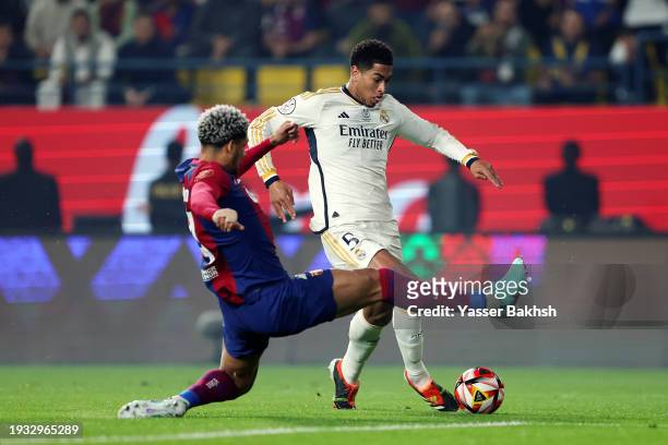 Jude Bellingham of Real Madrid is challenged by Ronald Araujo of FC Barcelona during the Super Copa de España Final match between Real Madrid and FC...