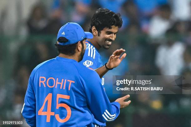 India's Washington Sundar celebrates with his captain Rohit Sharma after taking the wicket of Afghanistan's Azmatullah Omarzai during the third and...