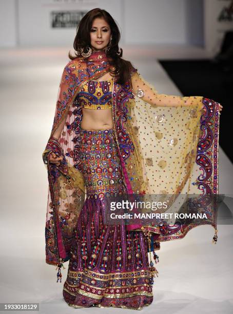 Indian actress Urmila Matondkar presents a creation by Indian designer Jaya Rathore during the Wills India Fashion Week Spring Summer 2010 in New...