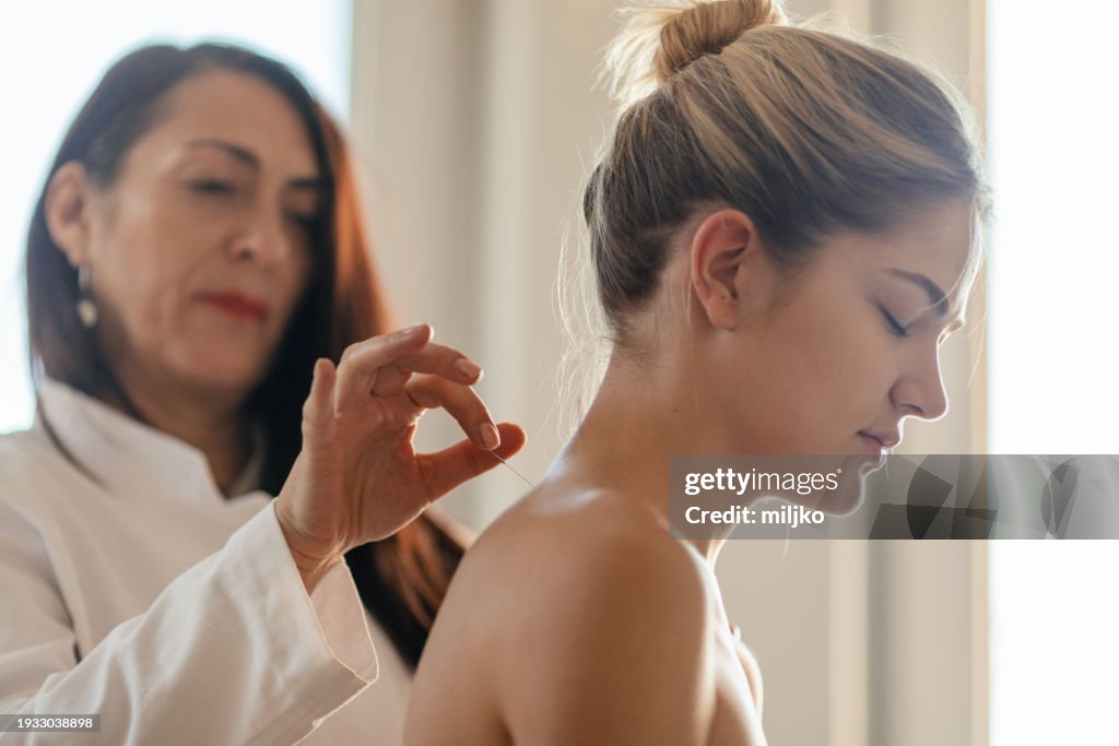 Acupuncture back treatment, therapist and patient